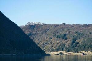 fiordo con montagne su orizzonte. acqua luccica nel il sole nel Norvegia. paesaggio foto