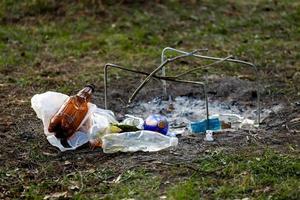 un mucchio di spazzatura nel parco forestale vicino al sito del falò foto