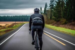 ciclista atleta cavalcate su un vuoto strada su un' strada bicicletta generativo ai foto