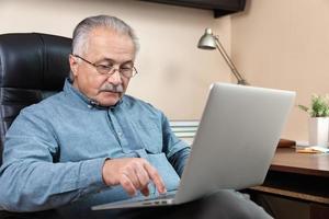 uomo anziano impara a usare il computer foto