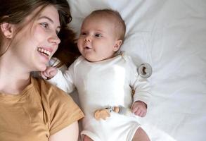 mamma e figlia che ride felici si trovano sulla schiena foto