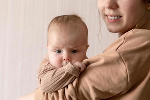 una giovane madre tiene in braccio una bambina di 3 mesi