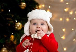 il bambino di Natale sorride e tiene una ghirlanda con i cuori foto