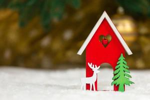 cervo di casa di legno del giocattolo di Natale e albero su una coperta bianca che imita la neve