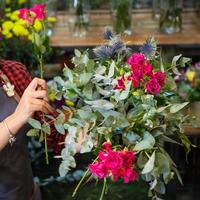 donna fioraio che fa bouquet di fiori presso il negozio