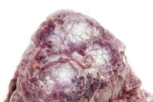 macro minerale pietra lepidolite nel il roccia un' bianca sfondo foto