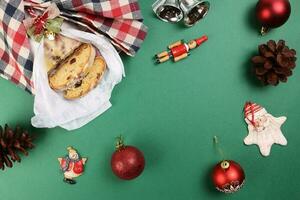 Natale natale decorazione ornamento campana regalo avvolgere affettato Stollen frutta torta cibo pino frutta su verde sfondo foto