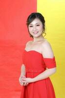 asiatico donna moderno rosso vestito su giallo rosso multicolore carta sfondo agitando mano foto
