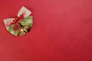 piccolo Natale natale regalo arco nastro pino preparativi campana su rosso sfondo copia testo spazio foto