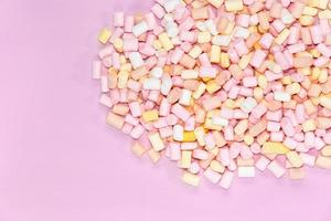 marshmallow multicolori su uno sfondo rosa monocromatico foto