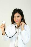 giovane asiatico femmina medico indossare grembiule Tenere stetoscopio foto