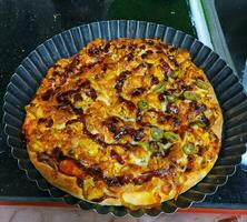 fatti in casa Pizza nel nero piatto ,pollo formaggio delizioso veloce cibo per pranzo foto