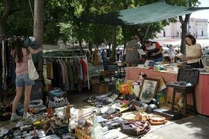 13 Maggio 2023, Lisbona, Portogallo - persone l'esame il merce su Schermo a il famoso feira da ladra - Pulce mercato - nel Lisbona, Portogallo. foto