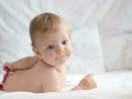 bambino su letto giocando con perline foto