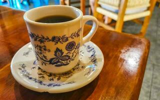 blu bianca tazza pentola con nero caffè di legno tavolo Messico. foto