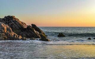 surfer onde turchese blu acqua rocce scogliere massi puerto escondido. foto