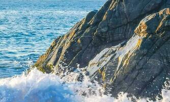 surfer onde turchese blu acqua rocce scogliere massi puerto escondido. foto