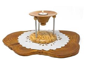 candeliere in legno multiparte con candela accesa si trova su una tavola di legno scuro foto