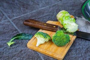 broccoli crudi tagliati in un tagliere di legno foto