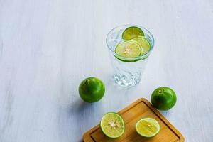 un bicchiere di soda, limone e lime sul tavolo foto