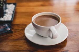 una tazza di caffè su un tavolo di legno in una caffetteria foto