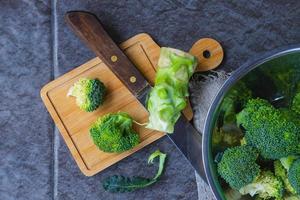broccoli crudi tagliati in un tagliere di legno foto