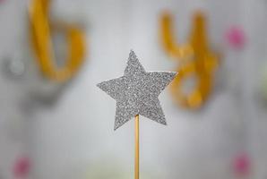 decorazione a stella d'argento realizzata con glitter su sfondo grigio