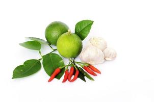 limone verde e foglie con peperoncino e aglio e su sfondo bianco foto