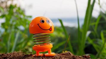 una foto di una bambola giocattolo arancione con un'espressione sorridente