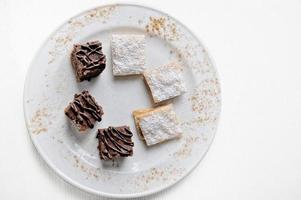 deliziosi brownie al cioccolato e alfajores su uno sfondo bianco foto