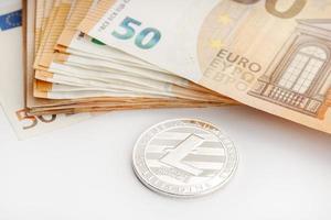 moneta litecoin e banconote in euro denaro blockchain contro il concetto di denaro fiat foto