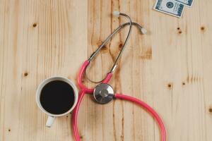 rosa stetoscopio è medico strumenti con caldo caffè su di legno. foto