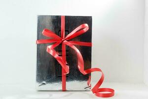 argento regalo scatola su bianca sfondo. argento regalo scatola con rosso nastro. foto