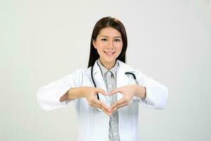 giovane asiatico femmina medico indossare grembiule stetoscopio cervo amore mano cartello foto