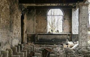 il bombardato edificio di il Casa di cultura nel il città. guerra di Russia contro Ucraina. distrutto pavimento travi dentro il costruzione, quale era colpire di un artiglieria guscio, razzo o aria bomba. foto