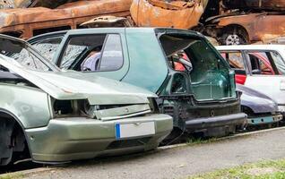 un' lotto di rotto macchine dopo un' traffico incidente nel il parcheggio lotto di un' servizio stazione. vendita di assicurazione emergenza veicoli a asta. foto