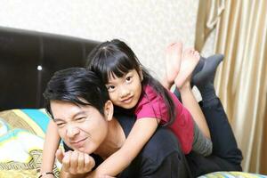 Sud est asiatico giovane padre madre figlia genitore ragazza bambino attività interno foto