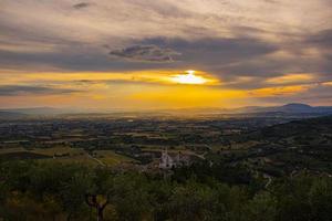 basilica di san francesco in assisi con uno splendido tramonto foto