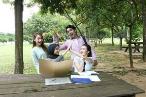 giovane asiatico malese Cinese uomo donna all'aperto parco libro file cartella il computer portatile computer Telefono sedersi In piedi studia mescolarsi foto