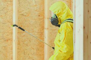 lavoratore nel sicuro respirazione maschera disinfezione edificio interno foto