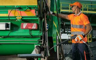 spazzatura camion lavoratore con pressione rondella lancia nel il suo mani foto