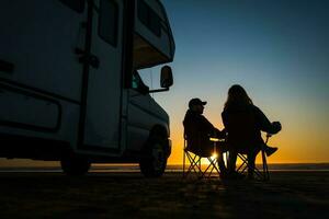 caucasico coppia rilassante Il prossimo per loro rv camper su un' spiaggia foto