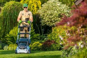 caucasico uomini falciatura erba nel il suo giardino foto