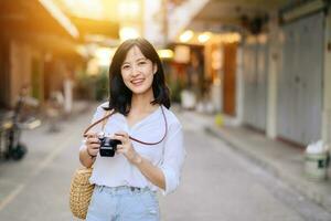 ritratto di asiatico donna viaggiatore utilizzando telecamera a strada di bangkok, Tailandia. Asia estate turismo vacanza concetto foto