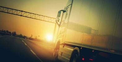 semi camion equitazione su autostrada a tramonto. foto