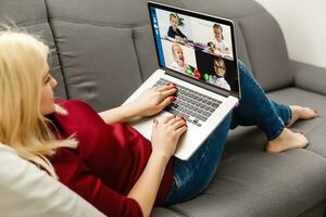 ritagliata Immagine di giovane donna utilizzando il computer portatile per video conferenza a casa foto