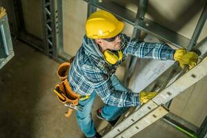 costruzione lavoratore utilizzando estensione scala foto