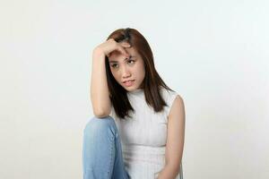 giovane attraente asiatico Cinese malese donna posa viso corpo espressione modalità emozione su bianca sfondo pensare preoccupazione seduta gambe su foto
