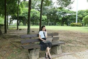 giovane asiatico Cinese donna all'aperto parco città universitaria libro foto