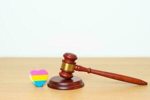 pansexual orgoglio giorno, LGBTQ legge e orgoglio mese concetti. martelletto giustizia martello con rosa, giallo e blu cuore forma per lesbica, gay, bisessuale, transgender, queer, intersessualità foto